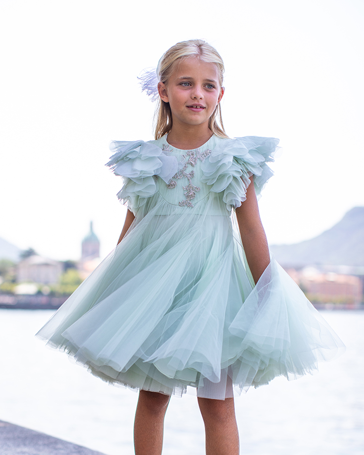 Girl in a mint tulle ruffled dress by the lake